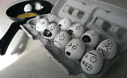 carton of eggs drawn faces stress one cracked in pan