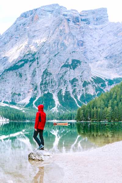 time outside and health man in red jacket by mountain lake