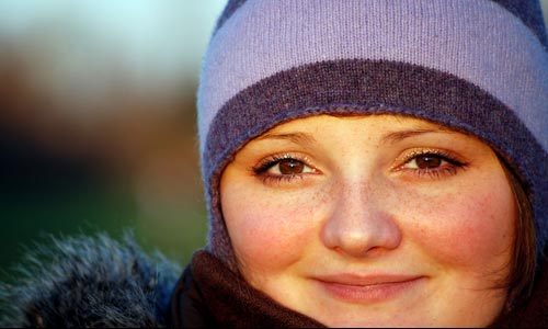 young girl in purple hat winter happy round face